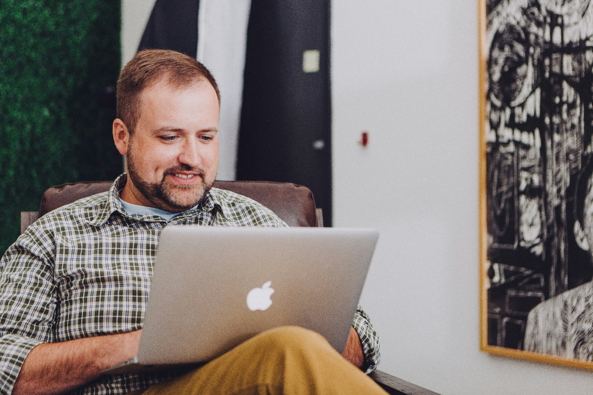 Homeowner relaxed in an armchair using Manse on a laptop